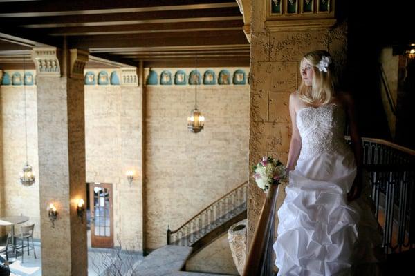 The balcony overlooks the elegant main lobby featuring a grand staircase, open ceiling and historic decor.