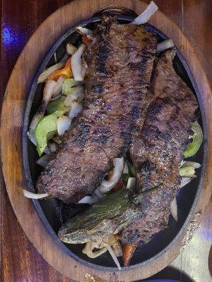 Carne Asada part of my plate on top of grilled onions and bell peppers. Was so flavorful!