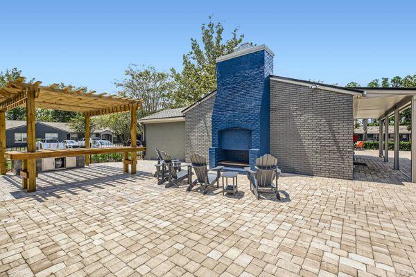 Outdoor fireplace, pergola, and outdoor BBQ area by the pool