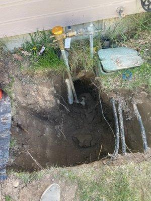 An in-progress photo the plumber sent me that shows the hole they dug. The sprinkler manifold box was exposed with an excavator.