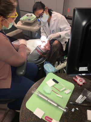 Dr Piya putting a crown on my wife's tooth  she's incredible