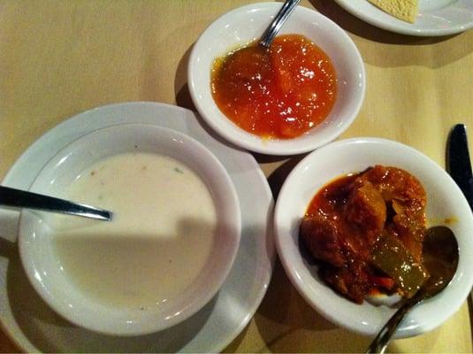 The accompaniments. Clockwise from top: Mango chutney, mango pickle, raita.