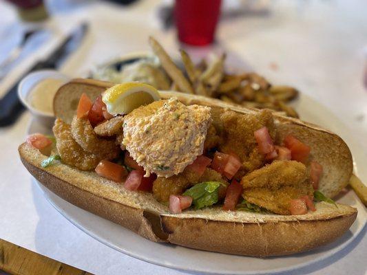 Shrimp po-boy sandwich  with a scoop of palmetto cheese on top.