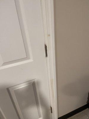 Dirty door leading into the bathroom. Stains or just dirt from someone's finger.