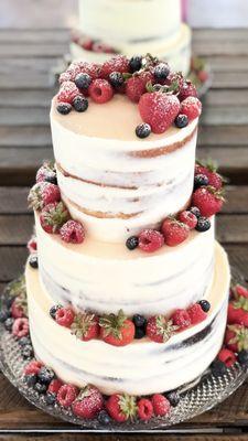 Custom three tier wedding cake topped with fresh fruit.