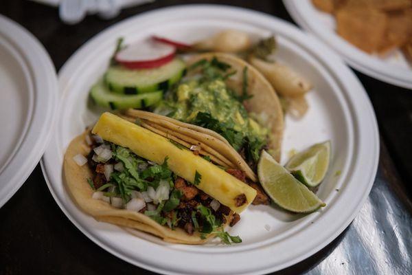 Tacos al pastor con pina (porn and pineapple) in the foreground; carne asada with guacamole in the background. Both were excellent.