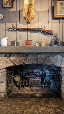 The shotgun mounted to the wall, and the fireplace