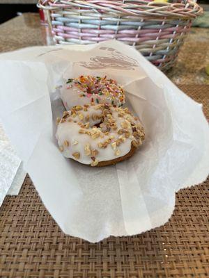 White chocolate cake donuts one with sprinkles and one with nuts