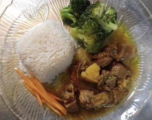 Curry goat white rice and broccoli and carrots