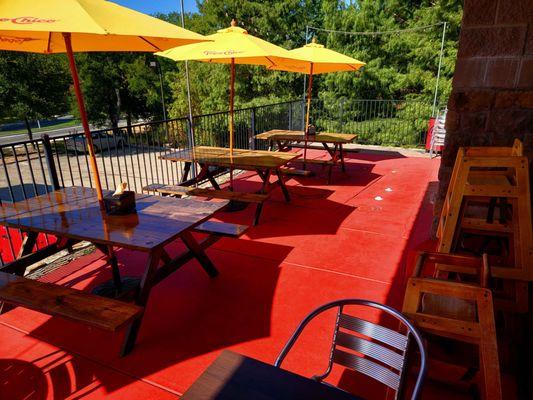 Outdoor balcony has tables for 4, and these picnic tables, child highchairs.