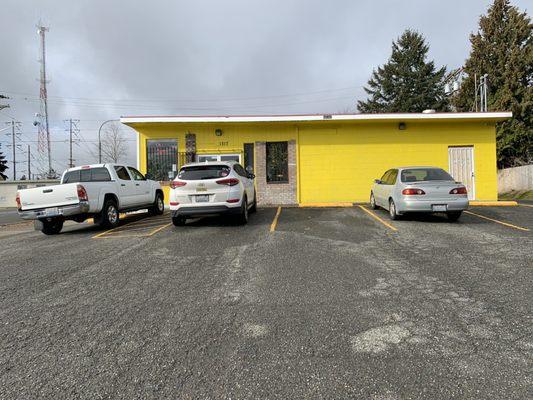 Entrance beyond the cars in the parking lot.