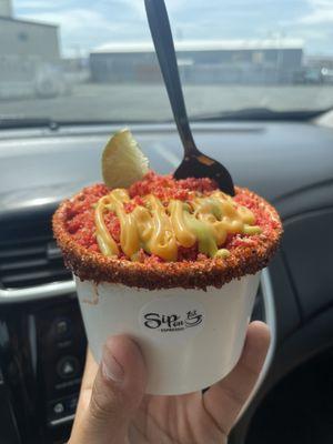 This is amazing corn in a cup with hot Cheetos or takis  Nachos cheese and green stuff