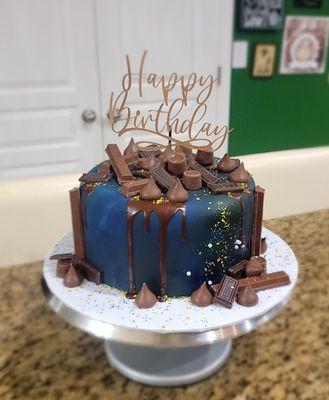 Chocolate cake cover with fondant and a lot of chocolate candies on top