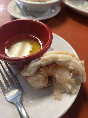 Part of a lobster tail with clarified butter