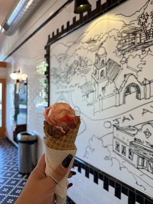 Strawberry cheesecake and chocolate on a waffle cone