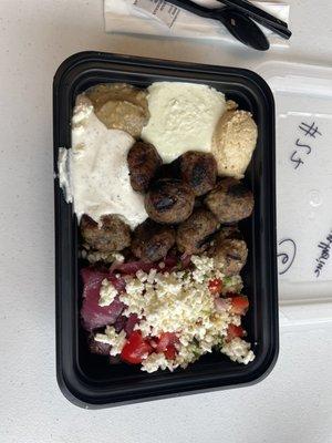 Grain bowl with meatballs hummus, feta fire, roasted eggplant, dill yogurt, tomato and cucumber, pickled onion, & feta