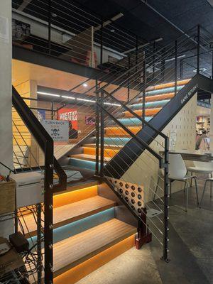 Colorful stairs to upstairs seating area.