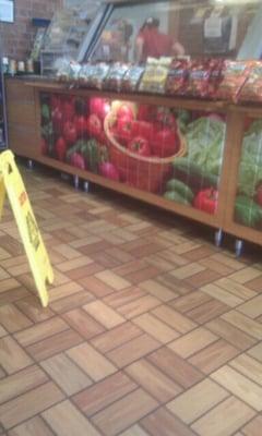 Wet floor sign blocking entire walkway while employees stand behind the counter talking.