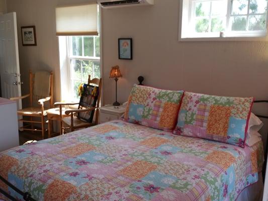 Queen bed and sitting area in Primrose Cottage