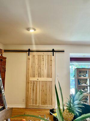 Final look- Classic modern natural wood barn door with mute black metal rail, enforced with extra matching wood slab.