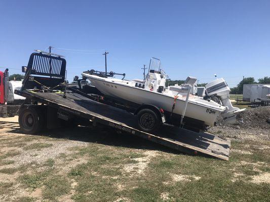 Broken trailer and boat on tow truck