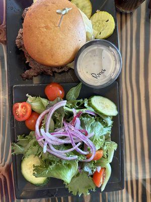 Philly steak sandwich on a gluten-free bun with a side salad