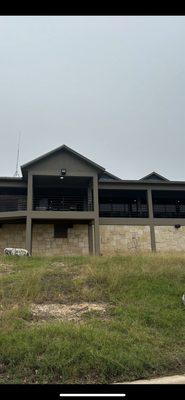 The rear of the clubhouse.  Tables and chairs along the balcony, inviting for a brew and a Cuban after the round.