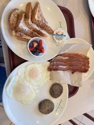 French toast, eggs, sausage patties, and bacon.