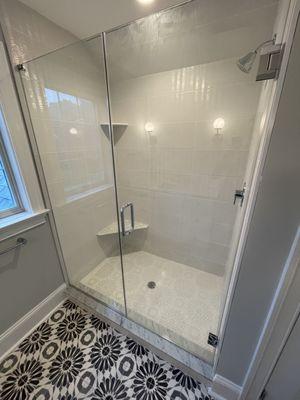 Large white  tile shower with floral tiles on floor