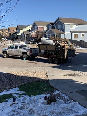 A mountain of bagged junk, boxes, two mattresses, swing set, two dead Christmas trees and a large two-piece chicken coop.