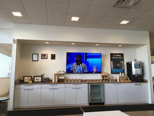 Waiting area with tv, single serve coffee/cappuccino maker and single serving packaged snacks.