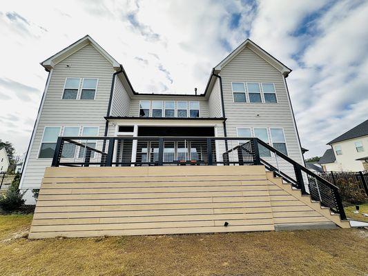 Horizontal slatted composite deck skirting and TimberTech Drink railing with cable infill