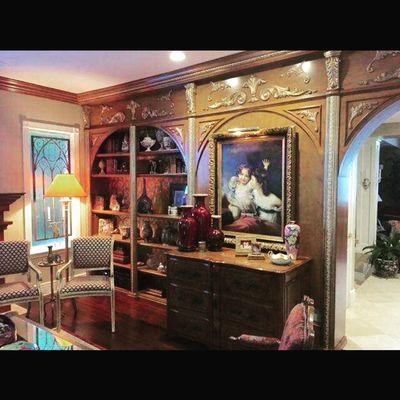 Custom bookcase and wall panels with gold carvings and moldings.