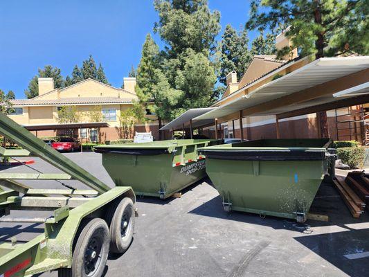 A large apartment complex with multiple roll off dumpsters on sote for remodeling