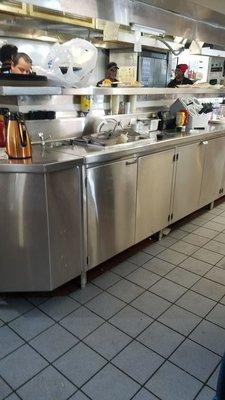 This expo line is completely filthy! Trash on the counters, dirty dishes. To think our food was plated and trayed above it.