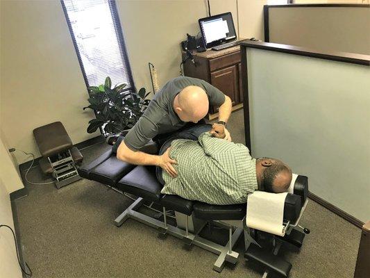 Chiropractor Charlotte NC adjusting patient with lower back pain