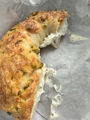 Jalapeño cheese bagel toasted with garlic herb cream cheese and cut in half