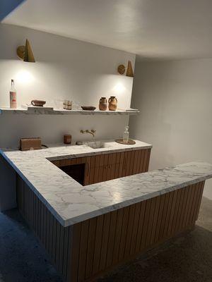 Custom bar installation with solid rift cut white oak.  Wood slats and floating stone shelf.