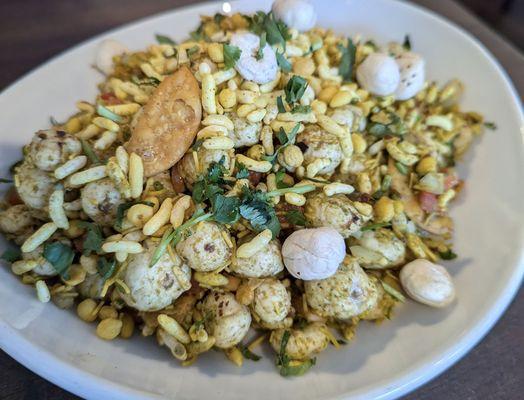 The quirky Makhana Bhel appetizer, a large bowl of popped lotus seeds, green mango, tomato with a tamarind chutney sauce.