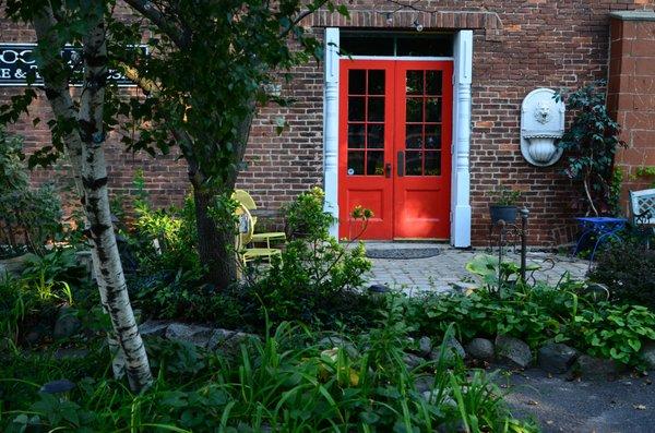 Side entrance surrounded with old growth trees and beautiful gardens.