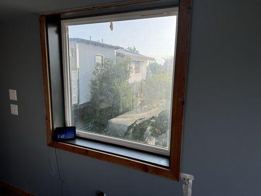 Main bedroom window. No curtains and cheap tacky command strips on the window.