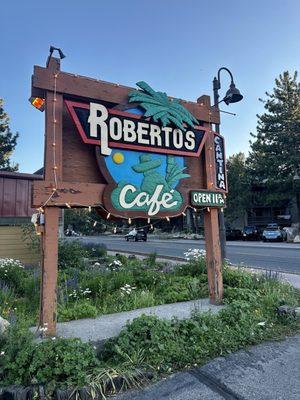 Sign by driveway in Roberto's Cafe.