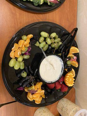 Fruit tray (half eaten). It included star fruit, pears, oranges, strawberries, grapes, blueberries