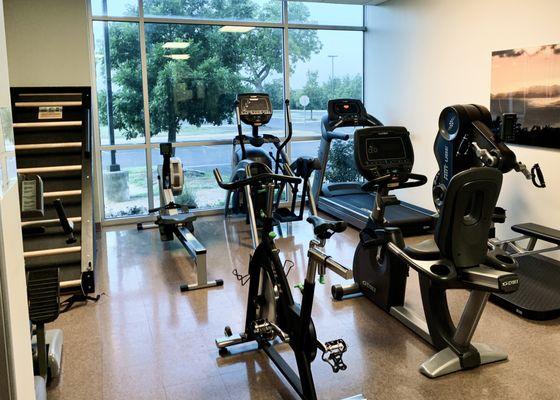 Cardio area with a rower, bikes, treadmill, elliptical, Jacob's ladder, and upper body bike (UBE)