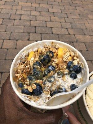 Overnight Oats with Yogurt, topped with Granola, Peanut Butter Sauce, Mangos, and Blueberries