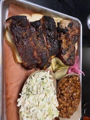 Overcooked ribs and fatty pork steak with a side of undercooked beans