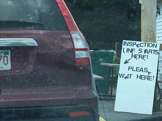 Sign at front of line, note bench behind