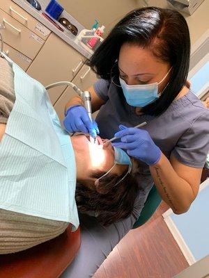 Dental assistant Jalessa Jones performs cleaning on patient.