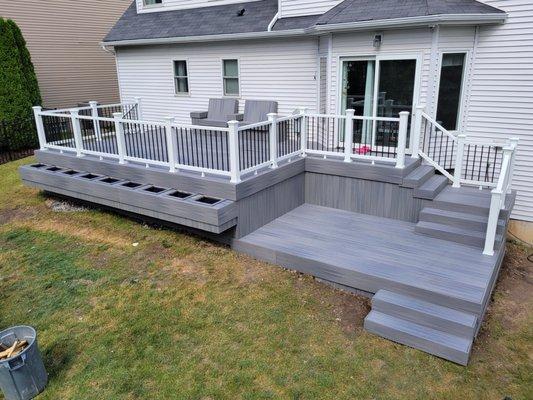 Fiberon's Beach House decking with matching Fascia, and Trex's white railings holding black aluminum balusters / spindles.