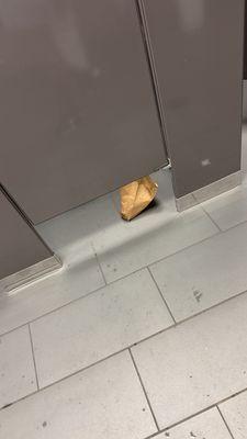 Some women decided to empty the trash in the stall and place it on the floor. Nasty!